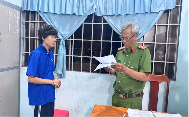 Công an đọc lệnh giữ người đối với H.T.T. Ảnh: Công an Vĩnh Long