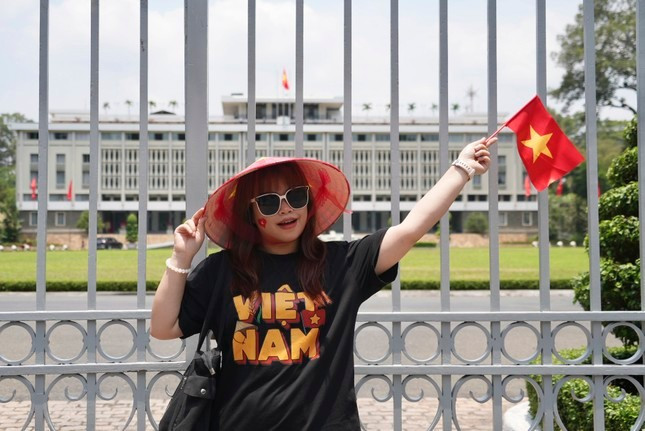 Một cô gái vẫy cờ đỏ sao vàng chụp ảnh trước Dinh Độc Lập. (Ảnh: AP) Một cô gái vẫy cờ đỏ sao vàng chụp ảnh trước Dinh Độc Lập. (Ảnh: AP)