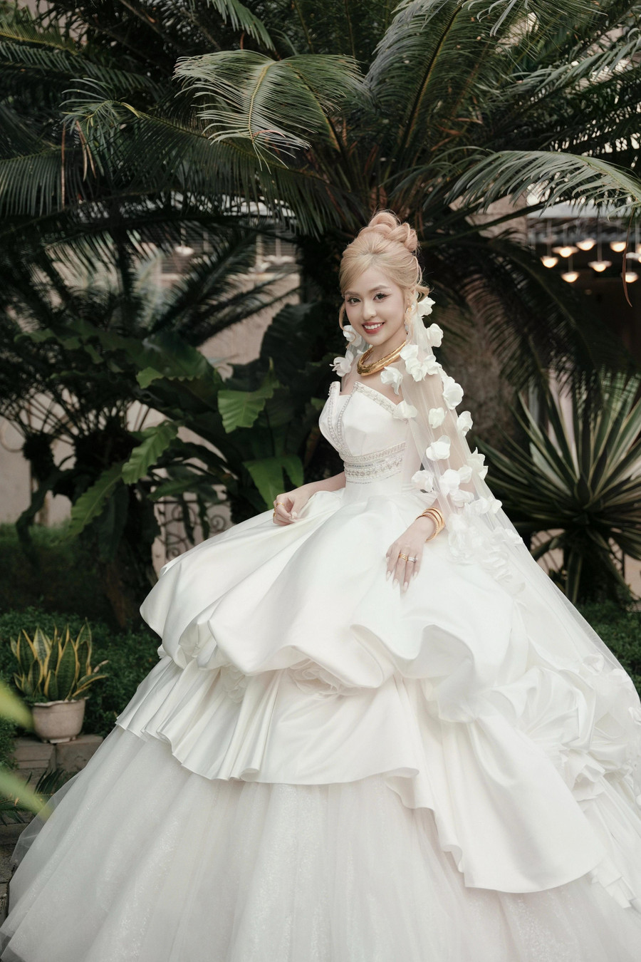 Nhằm mang đến vẻ đẹp hài hòa cho tổng thể, phần áo được Kim Anh sử dụng corset ôm sát cơ thể, kết hợp chi tiết xẻ sâu tôn vóc dáng nóng bỏng. Đối với phần thân váy, nhà thiết kế tạo chi tiết đa tầng, giúp Trần Thanh Tâm trở nên lộng lẫy hơn trong lễ cưới