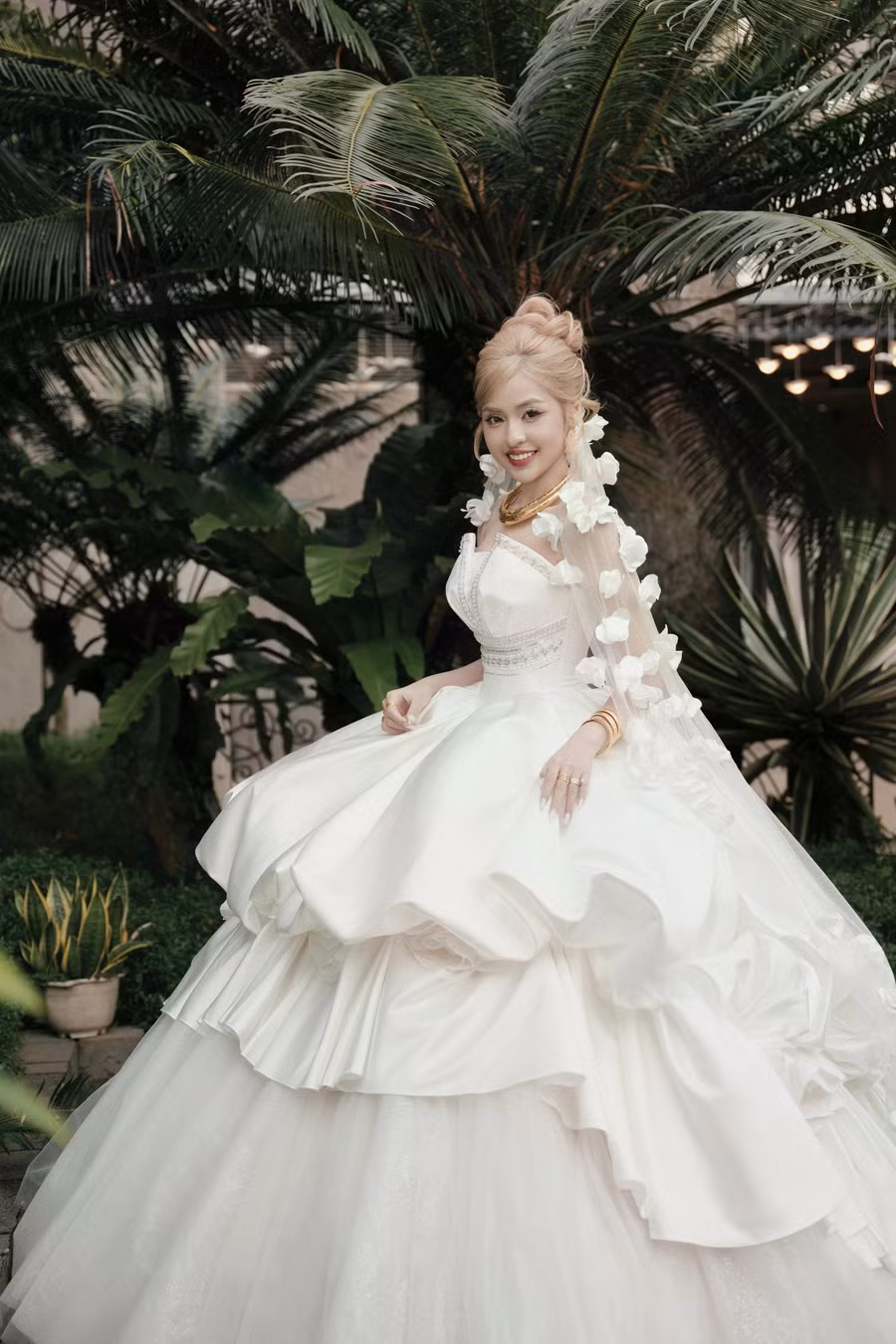 Nhằm mang đến vẻ đẹp hài hòa cho tổng thể, phần áo được Kim Anh sử dụng corset ôm sát cơ thể, kết hợp chi tiết xẻ sâu tôn vóc dáng nóng bỏng. Đối với phần thân váy, nhà thiết kế tạo chi tiết đa tầng, giúp Trần Thanh Tâm trở nên lộng lẫy hơn trong lễ cưới