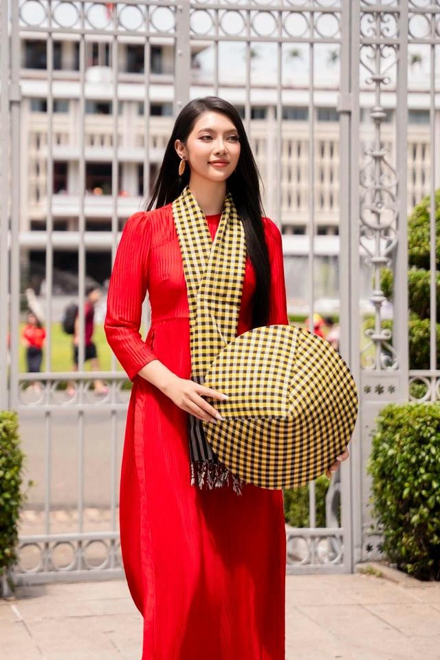 Áo dài đỏ phối khăn và nón họa tiết khăn rằn đến từ thương hiệu KHANRAN của stylist Thịnh Chocolate là một gợi ý cho quý cô trong mùa lễ. Khi diện bộ trang phục này xuống phố, Hoa hậu Đại dương Thu Uyên khéo léo phối cùng hoa tai tròn, tóc dài thẳng và giày cao gót tông trắng nổi bật