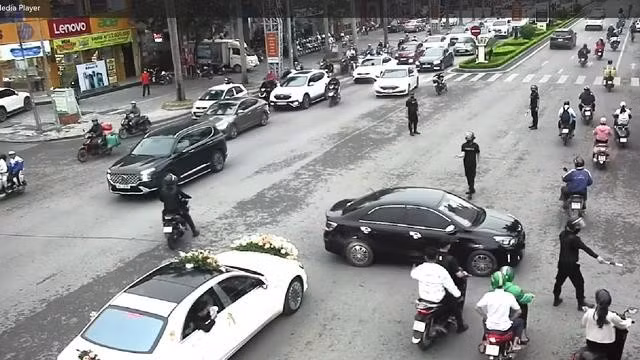 Nhóm vệ sĩ được trang bị trang phục, tay cầm dùi cui điều tiết giao thông cho đoàn xe đám cưới đi qua