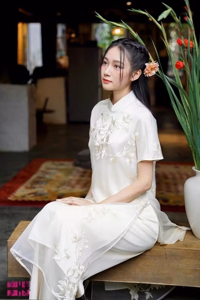 Gam màu trắng ngà tươi mới và giàu tính ứng dụng. Chất vải tơ thêu họa tiết nổi trên bề mặt kết hợp cùng kiểu cổ đứng thấp, tay ngắn mang lại sự dễ chịu và năng động cho nàng