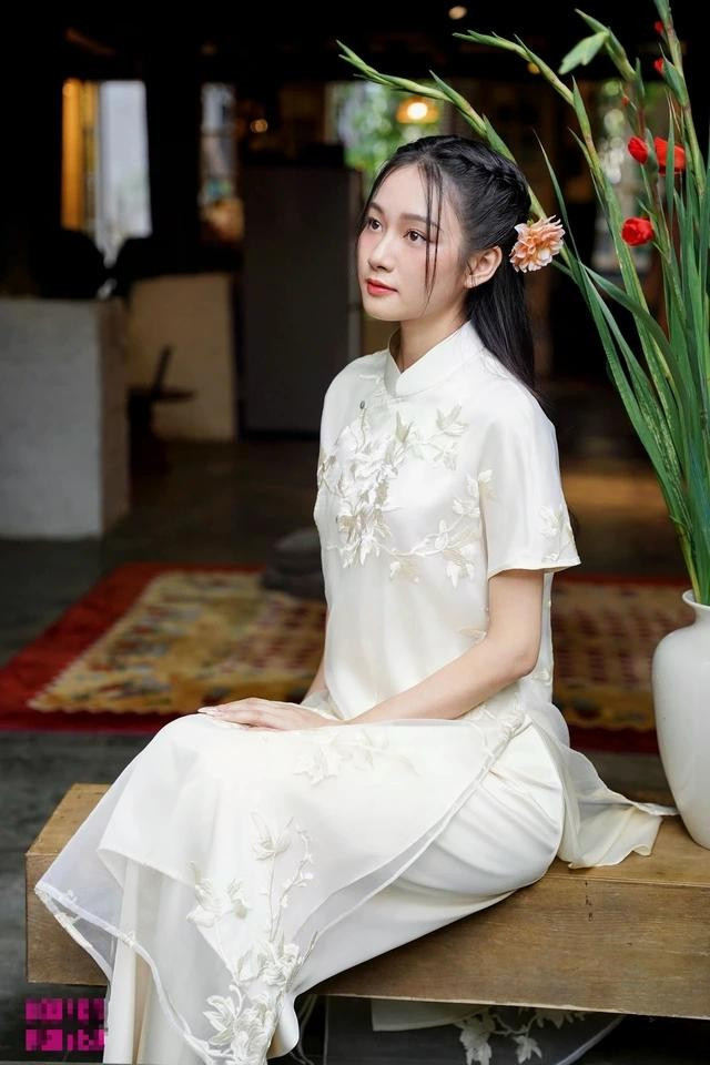 Gam màu trắng ngà tươi mới và giàu tính ứng dụng. Chất vải tơ thêu họa tiết nổi trên bề mặt kết hợp cùng kiểu cổ đứng thấp, tay ngắn mang lại sự dễ chịu và năng động cho nàng