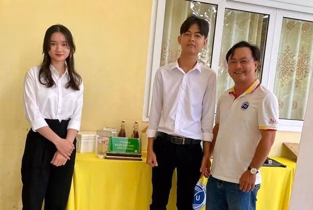 Trần Minh Điền (giữa) cùng sản phẩm mật thu hoạch từ dự án nuôi ong thông minh