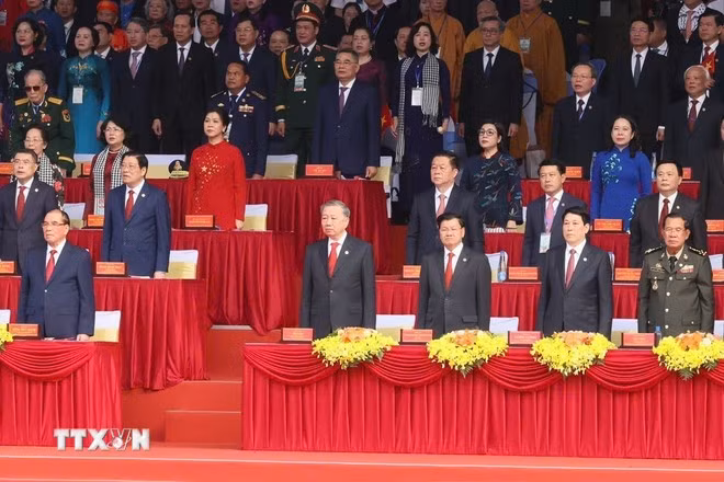 Các đại biểu thực hiện nghi lễ chào cờ. (Ảnh: TTXVN)