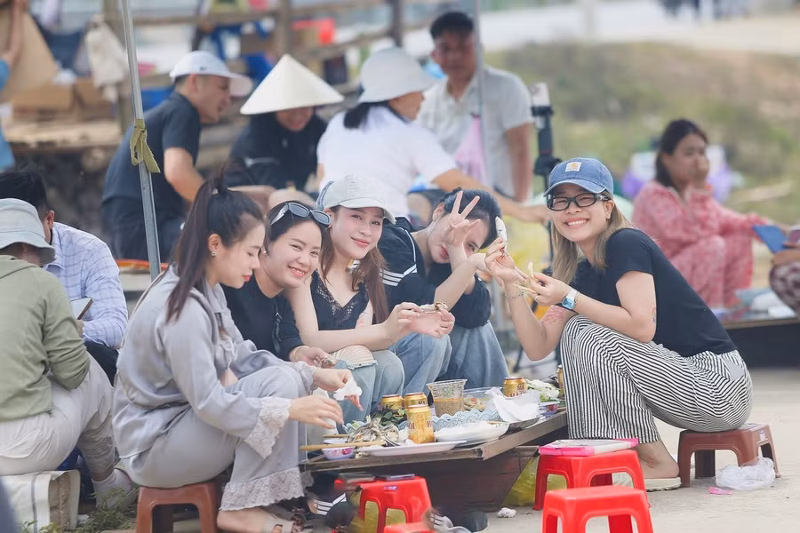 Khách du lịch thích thú thưởng thức món cá trích nướng tại bãi biển