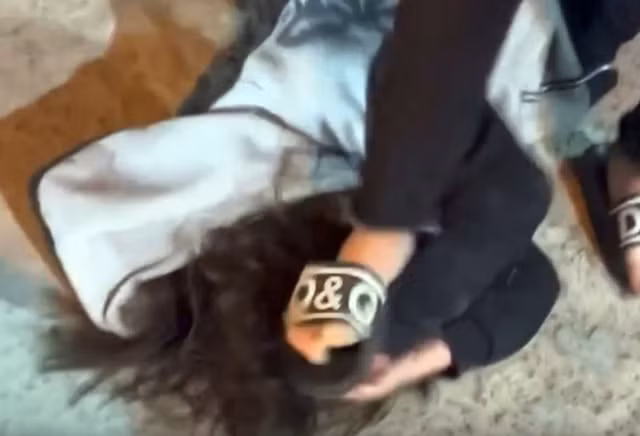 Nữ sinh nằm ôm đầu do bị nhóm thanh, thiếu niên hành hung. Ảnh cắt từ clip