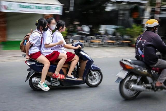 Trường hợp chở hai, ba người trên xe máy, không đội nón bảo hiểm khá phổ biến hiện nay Trường hợp chở hai, ba người trên xe máy, không đội nón bảo hiểm khá phổ biến hiện nay