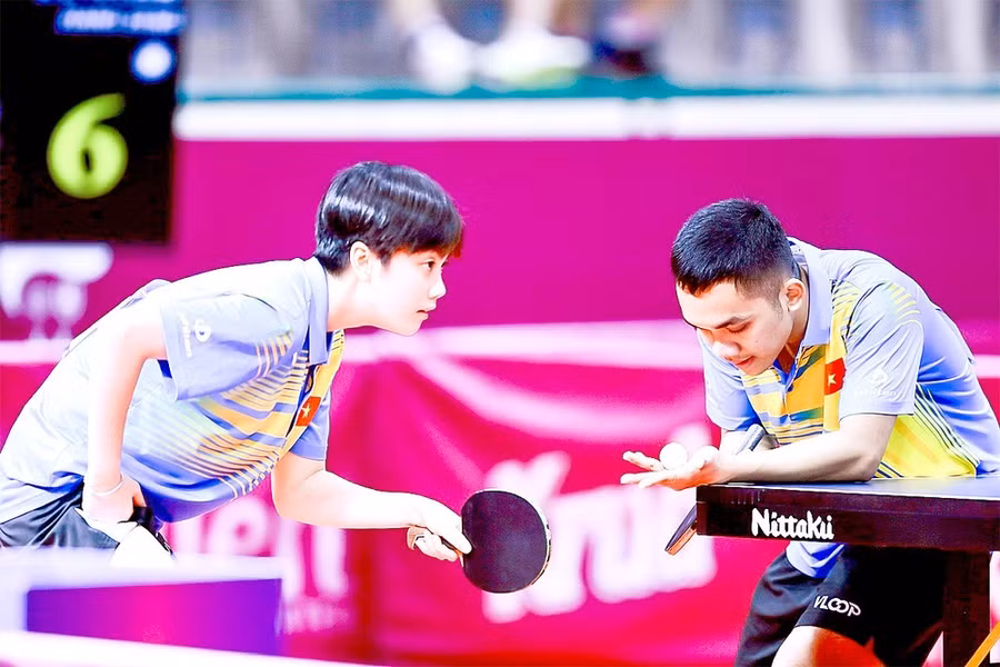 Hai tay vợt Đinh Anh Hoàng và Trần Mai Ngọc thi đấu trận chung kết đôi nam nữ tại SEA Games 32. Ảnh: DŨNG PHƯƠNG