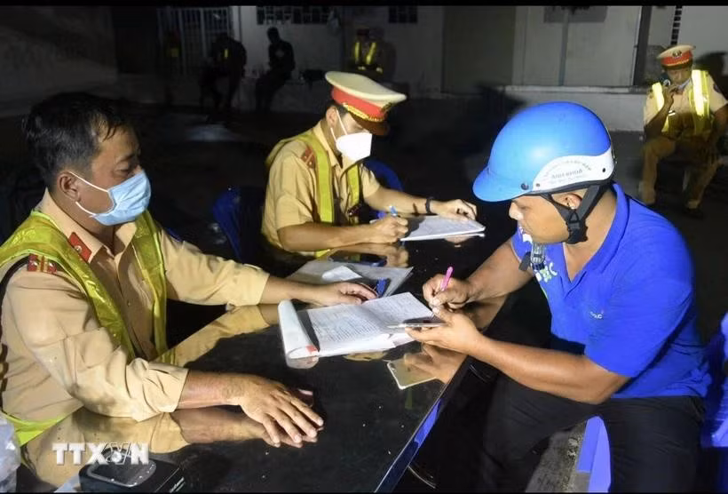 Lực lượng cảnh sát giao thông tỉnh Kiên Giang lập biên bản vi phạm hành chính người tham gia giao thông. (Ảnh: Lê Sen/TTXVN)