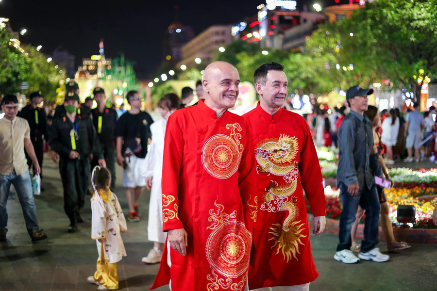 Khách nước ngoài mặc áo dài truyền thống đi dạo đường hoa