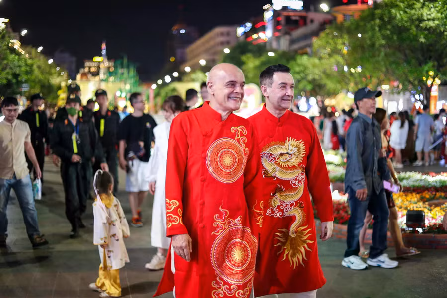 Khách nước ngoài mặc áo dài truyền thống đi dạo đường hoa