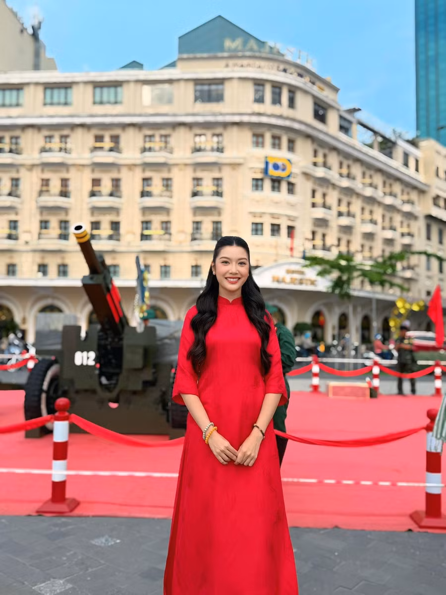 Á hậu Thúy Vân chụp ảnh với áo dài đỏ ở công viên bến Bạch Đằng - nơi đặt 18 khẩu pháo phục vụ lễ kỷ niệm 50 năm thống nhất đất nước.