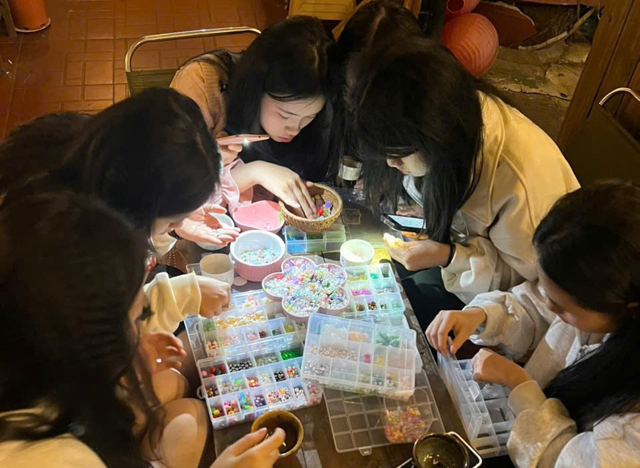 Các bạn trẻ say sưa đan vòng tay thủ công, hoạt động được tổ chức định kỳ tại Tiệm cà phê Ngã Ba Đường. Ảnh: Thanh Thảo cac-ban-tre-say-sua-dan-vong-tay-thu-cong-hoat-dong-duoc-to-chuc-dinh-ky-tai-tiem-ca-phe-nga-ba-duong-anh-thanh-thao.jpg