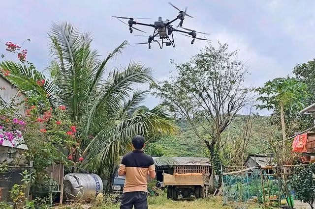 Anh Nguyễn Văn Nguyên điều khiển drone đi phun thuốc từ vườn nhà mình
