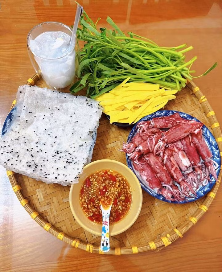 Mực trứng hấp giòn ngọt kết hợp với rau muống sống giòn mát, xoài chua ngọt và bánh tráng mè đen.