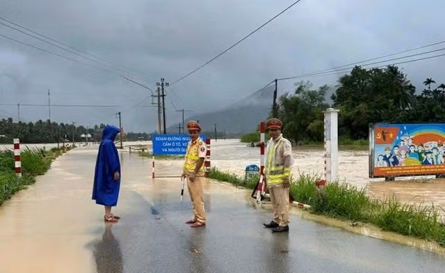 Lực lượng CSGT Bình Định túc trực không cho phương tiện qua lại tuyến đường bị ngập