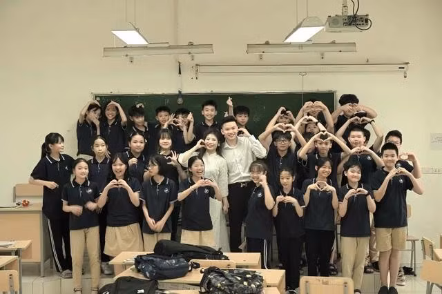 Quốc Nghĩa và Trà My chụp ảnh cưới cùng với các bạn học sinh trong lớp học