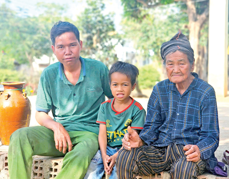 Bà Đinh Thị Khio (làng Jro Ktu Đak Yang) bên con cháu. Ảnh: H.T 22-2047.jpg