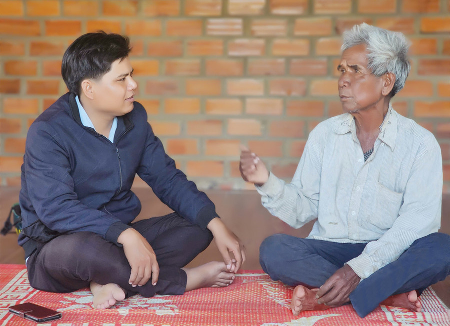 Ông Đinh Văn Khai (bìa phải, làng Klăh Môn) tự hào kể về những đóng góp của người dân cho cách mạng trong những năm kháng chiến. Ảnh: H.T 33-6624.jpg