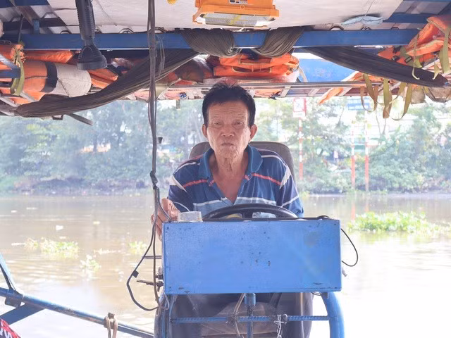 Ông Bảy lái đò đưa khách qua sông