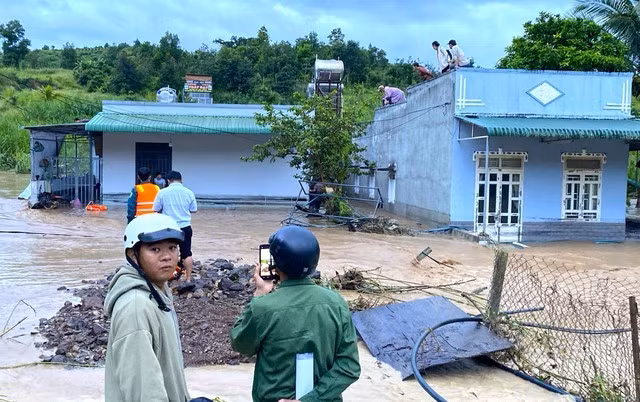 Một số người phải trèo lên dàn bồn nước hoặc mái nhà cao để tránh dòng nước chảy mạnh, chờ lực lượng chức năng đến giúp đỡ.