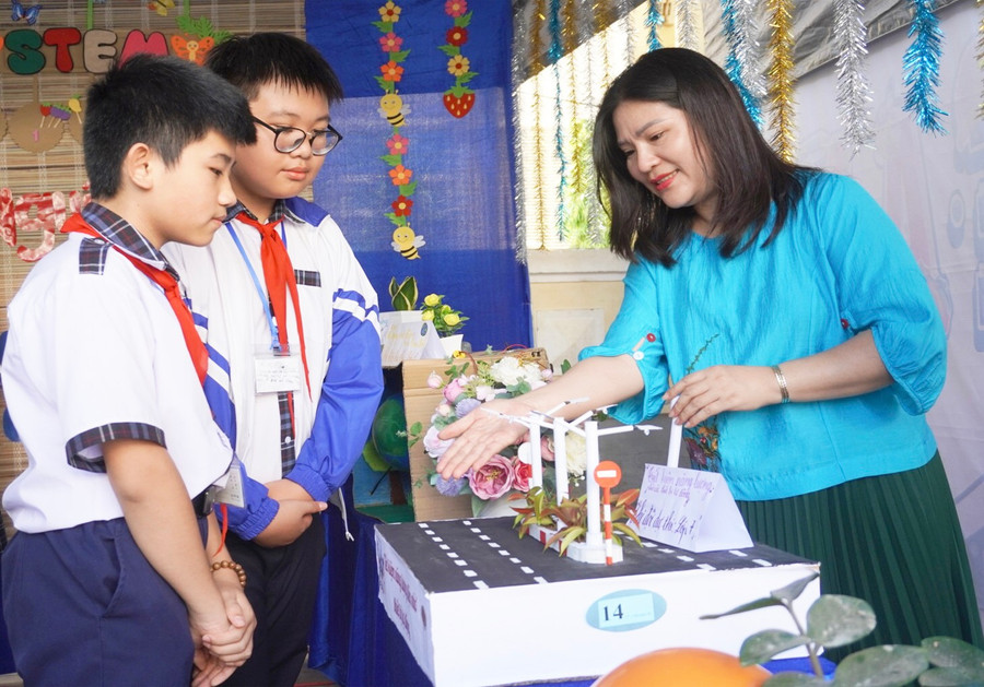 Cô Nguyễn Thị Ngọc Liên và các em học sinh tại gian hàng của lớp 7.7. Ảnh: C.H 1-7977.jpg