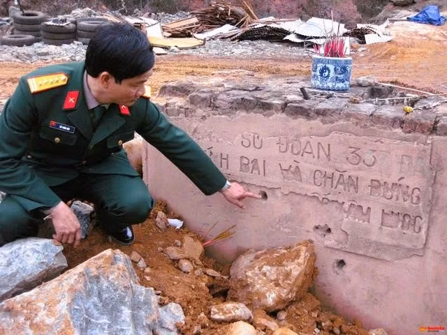 Đại tá Đỗ Phấn Đấu (nguyên Chính ủy Đoàn kinh tế - quốc phòng 337) bên tấm bia chiến công ở cạnh cầu Khánh Khê (cũ), được xây dựng năm 1980 (ảnh chụp trước năm 2012)