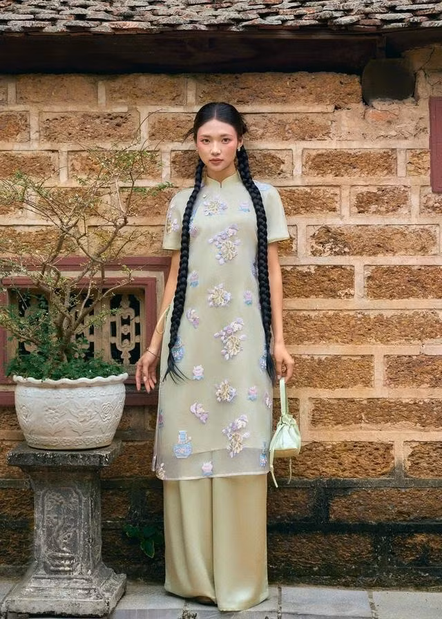 Trẻ trung và năng động với áo dài tay ngắn thoáng nhẹ, lạ mắt. Nàng có thể chọn kiểu tóc tết hai bên, tóc uốn cúp khi chụp ảnh với áo dài và đừng quên những món phụ kiện đặc trưng khi diện áo dài như các mẫu túi vải/túi cói, hoa cài tóc hoặc hoa ôm trên tay...