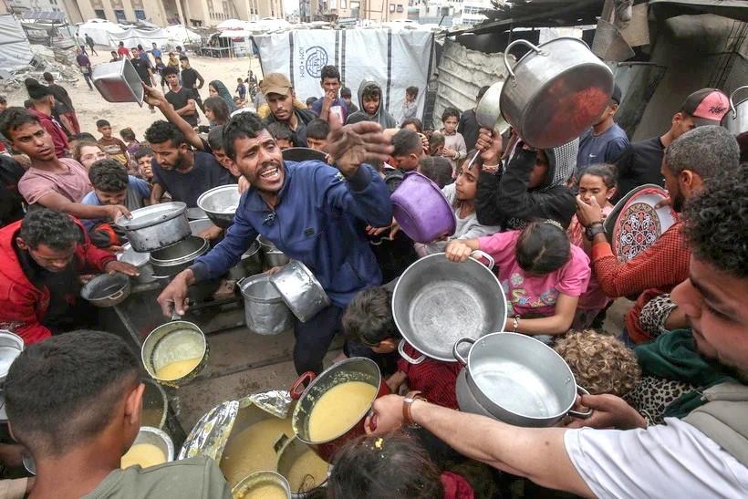 Người dân Palestine nhận thức ăn cứu trợ tại TP. Gaza ngày 12-5. Ảnh: THX/TTXVN nguoi-dan-palestine-nhan-thuc-an-cuu-tro-tai-thanh-pho-gaza-ngay-12-5-anh-ttxvn.jpg