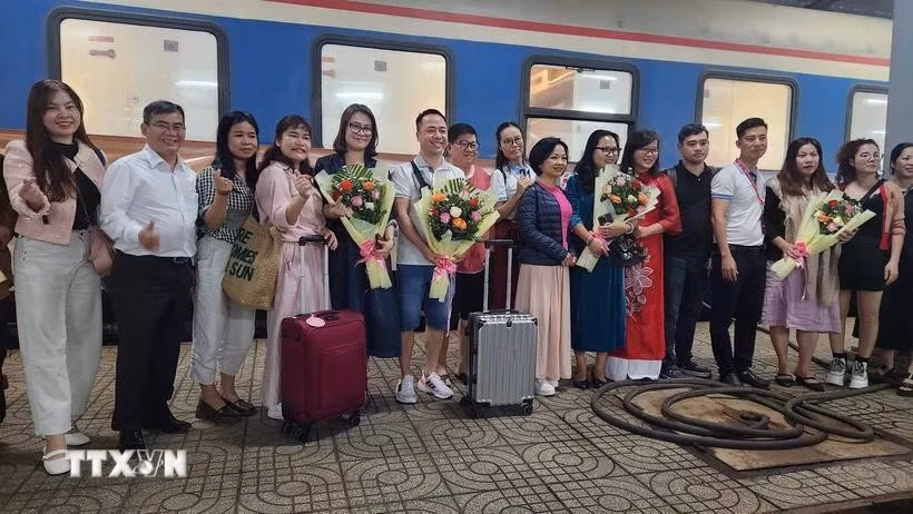 Bà Nguyễn Thị Kim Chung Phó Giám đốc sở Văn hóa Thể thao và Du lịch tỉnh Bình Định tặng hoa cho du khách. (Ảnh: Sỹ Thắng/TTXVN)