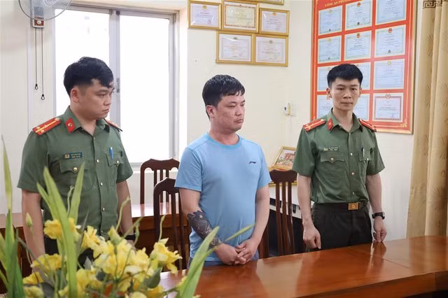 Đối tượng Lê Việt Hùng tại cơ quan công an. Ảnh: Bộ Công an