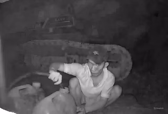 Người đàn ông chuyên dùng chó cảnh giới để hút trộm dầu của phương tiện thi công đường cao tốc Khánh Hòa - Buôn Ma Thuột. Ảnh cắt từ clip