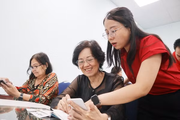 Tình nguyện viên Trần Nguyễn Ngọc Trang hướng dẫn học viên cách đăng nhập ứng dụng VneID.