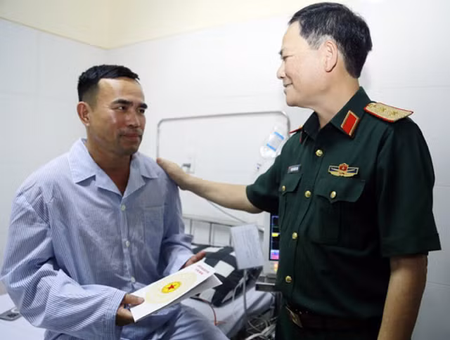 Trung tướng Phạm Trường Sơn thăm, tặng quà cho phi công Nguyễn Văn Sơn.