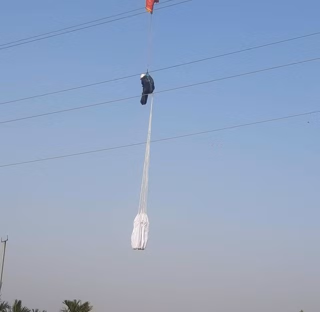 Người đàn ông treo lơ lửng giữa hai dây điện trần. Ảnh: F.B.