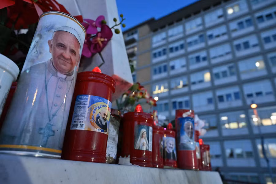 Ngọn nến in hình Giáo hoàng Francis (bìa trái) được đặt bên ngoài Bệnh viện Gemelli ở Rome