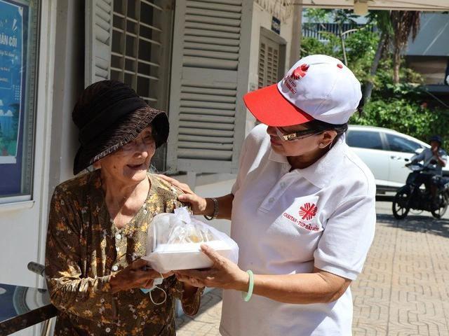 Cô Bông vừa trao cơm, vừa hỏi han sức khỏe của bà Đông Cô Bông vừa trao cơm, vừa hỏi han sức khỏe của bà Đông