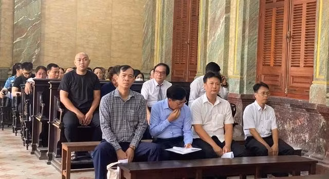 Một số bị cáo (hàng đầu tiên) chờ phiên xét xử bắt đầu