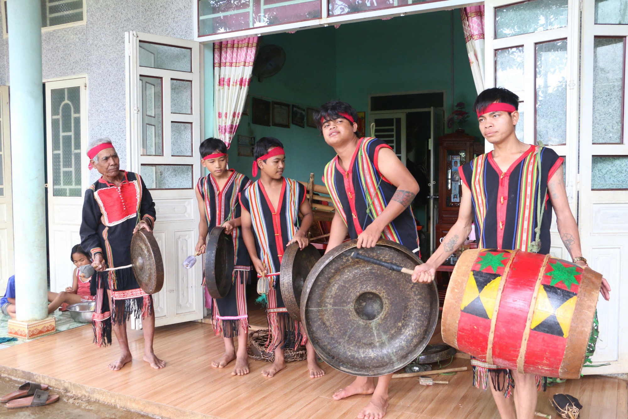 Nghệ nhân Ak (bìa trái) tập luyện cho đội cồng chiêng của làng Chuet 2, phường Thắng Lợi. Ảnh: Q.T nghe-nhan-ak.jpg