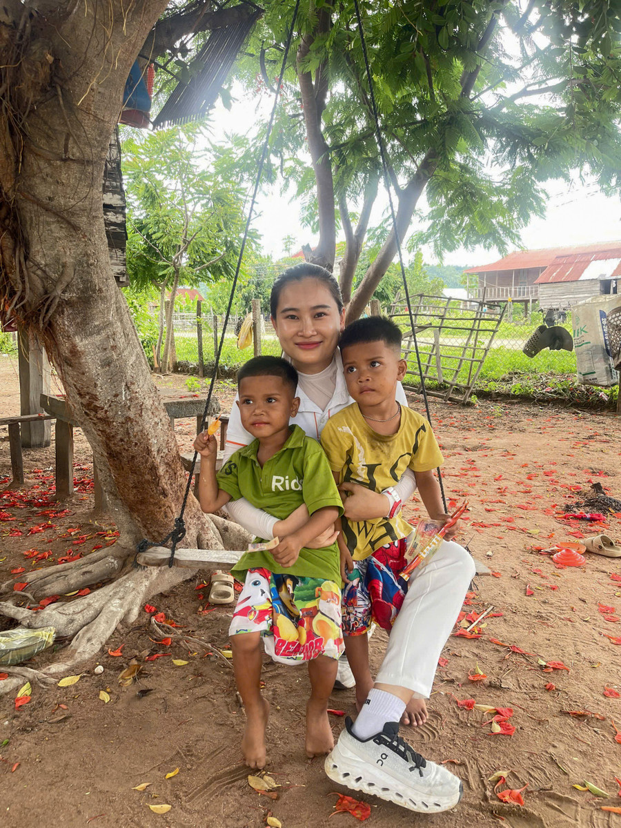 Mẹ đỡ đầu Hoàng Như Yến bên 2 anh em trai song sinh Đinh Thương, Đinh Thái (làng Plei Trớ, xã Chư A Thai) được chị nhận nuôi. Ảnh: Minh Châu 2-2704.jpg