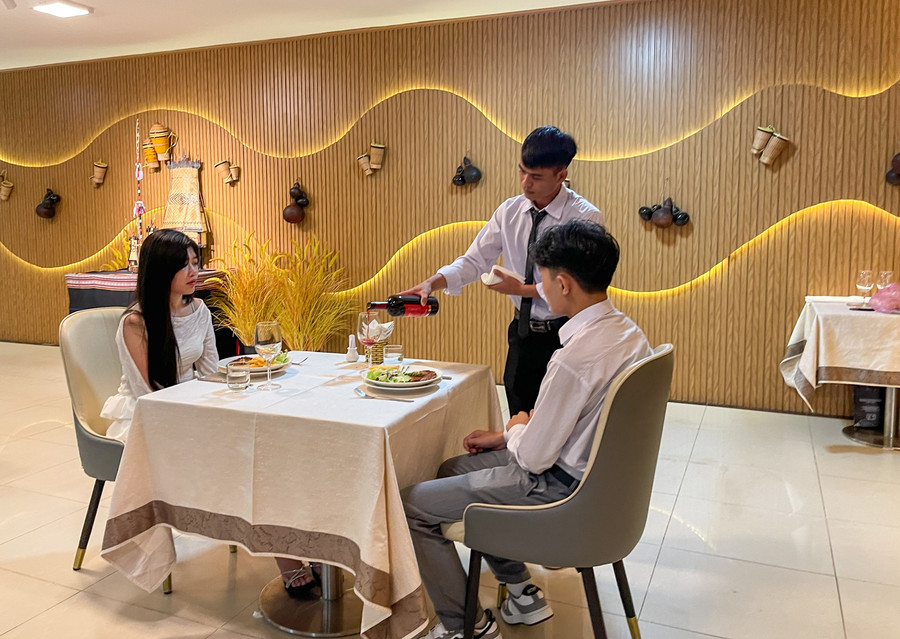 Thí sinh thực hiện quy trình rót rượu vang trong phần thi nghiệp vụ nhà hàng. Ảnh: Minh Châu img-1253.jpg