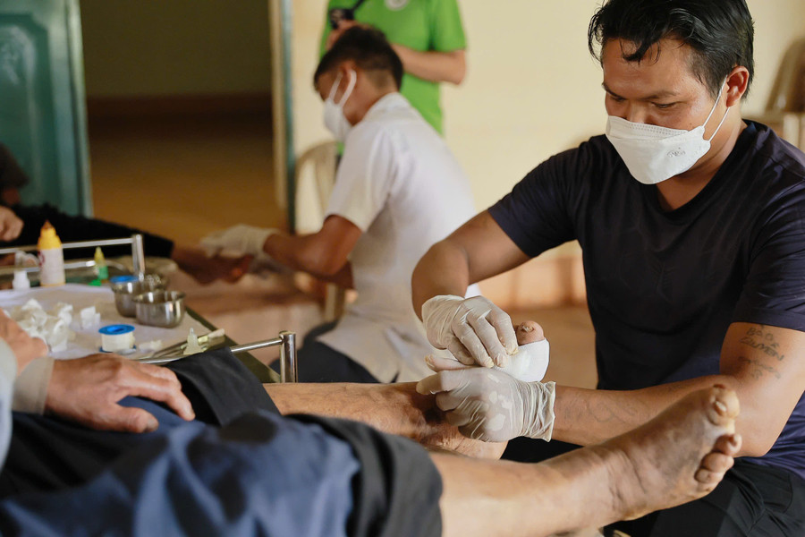 Các tình nguyện viên hỗ trợ chăm sóc, rửa vết thương cho bệnh nhân phong. Ảnh: ĐVCC img-4432.jpg