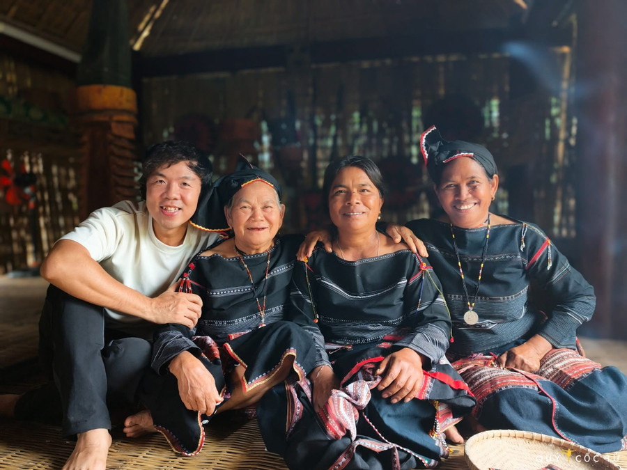 Turister tar bilder med Bahnar-håndverkere i landsbyen. Foto: Quoc Nguyen img-4454.jpg