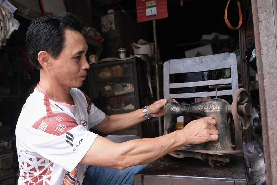Anh Nguyễn Văn Hoàng nâng niu chiếc đầu máy hiệu Singer của Pháp được sản xuất hơn 100 năm trước. Ảnh: Hoàng Ngọc dscf5646.jpg