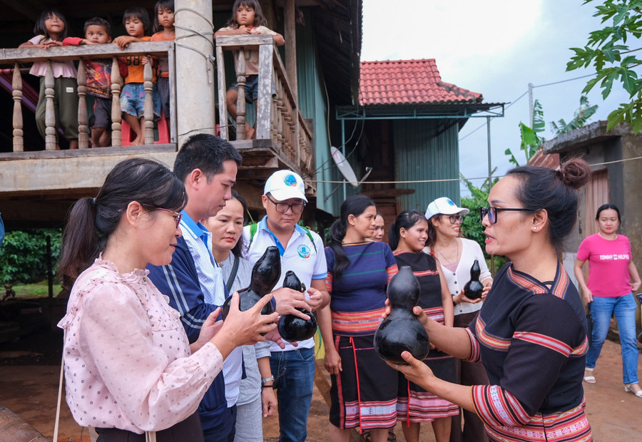 Đoàn khảo sát nghe hướng dẫn viên địa phương tại làng Kép (xã Ia Ly) giới thiệu bản sắc văn hóa của người Jrai. Ảnh: HOÀNG NGỌC h1.jpg