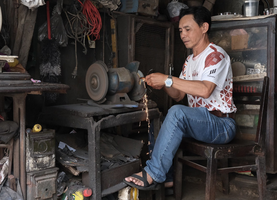 Chiếc ghế dựa người thợ ngồi mài kéo cùng những đồ vật khác bên trong cửa tiệm đều nhuốm màu thời gian. Ảnh: Hoàng Ngọc 3.jpg