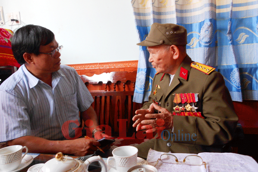 Tác giả đang nghe Đại úy Đinh Hỗ kể lại trận đánh của bộ đội ta ngày 7-5-1954 tại lòng chảo Mường Thanh và bắt sống tướng Đờ Cát. Ảnh: Hà Quân