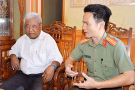 Anh Lê Ngọc Hưng (khi còn là Thiếu tá, Đội trưởng Đội An ninh Công an huyện Chư Prông) tiếp xúc tranh thủ già làng Rơ Mah Klua (làng Lâm So, xã Thăng Hưng) để vận động người dân chấp hành tốt các quy định của pháp luật. Ảnh: T.T.T